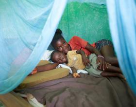 In Ghana, mother and son under an insecticide-treated bed net they received to protect them from mala